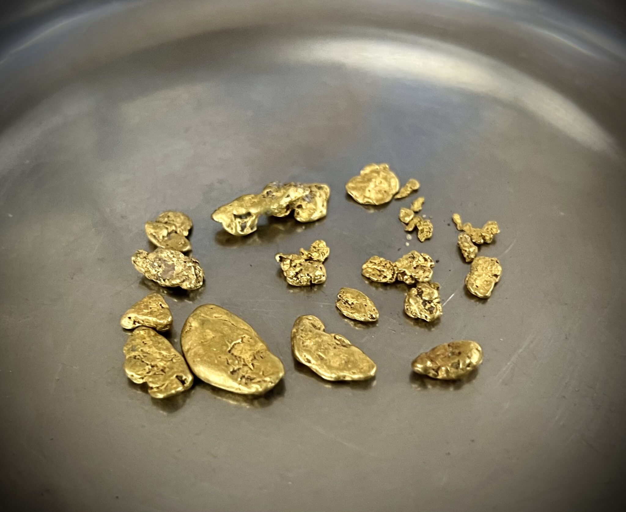 Small gold ingots scattered across an iron pan.