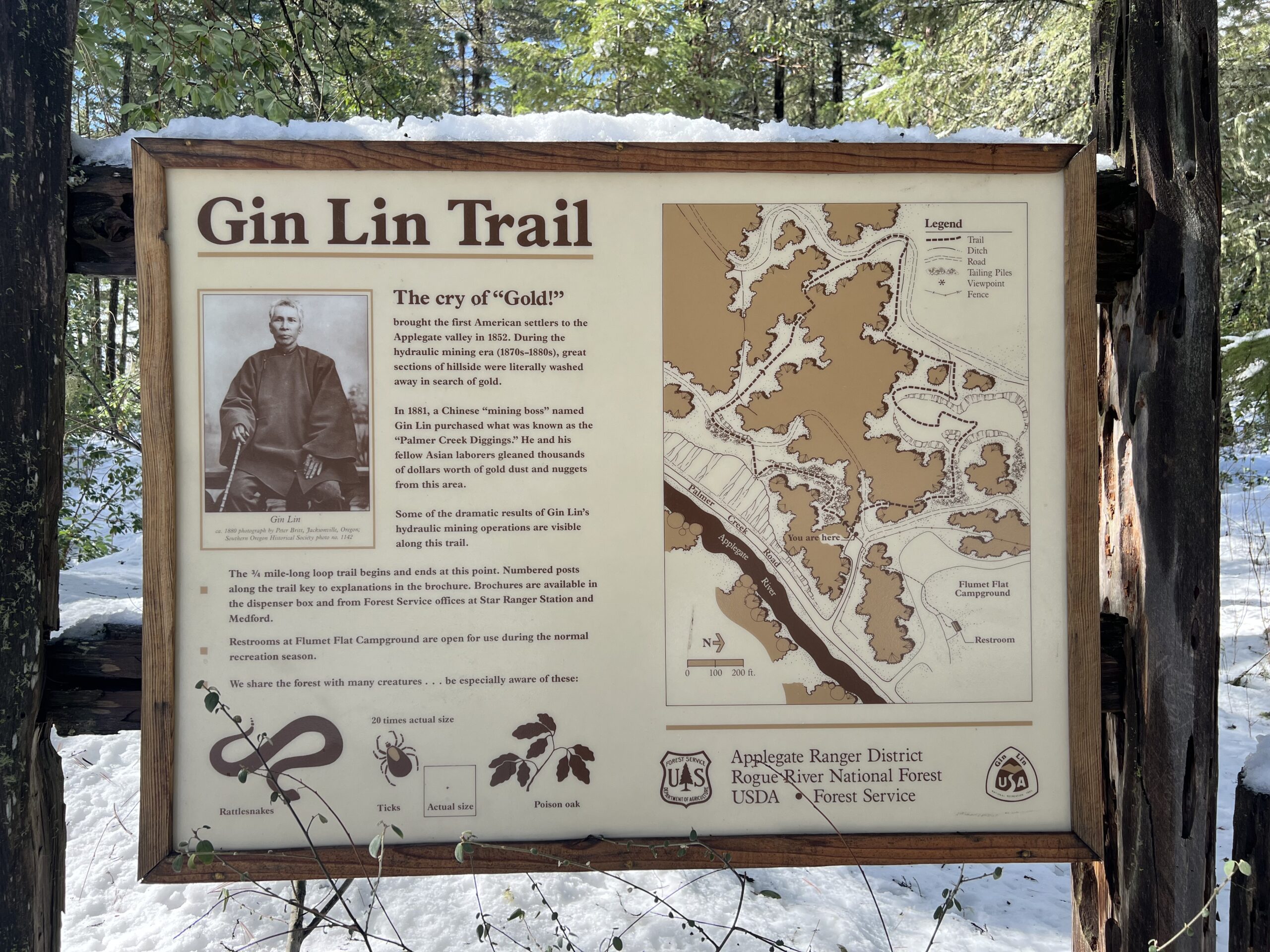 Gin Lin Trail map and history on a sign in front of the trail in a snowy Grants Pass