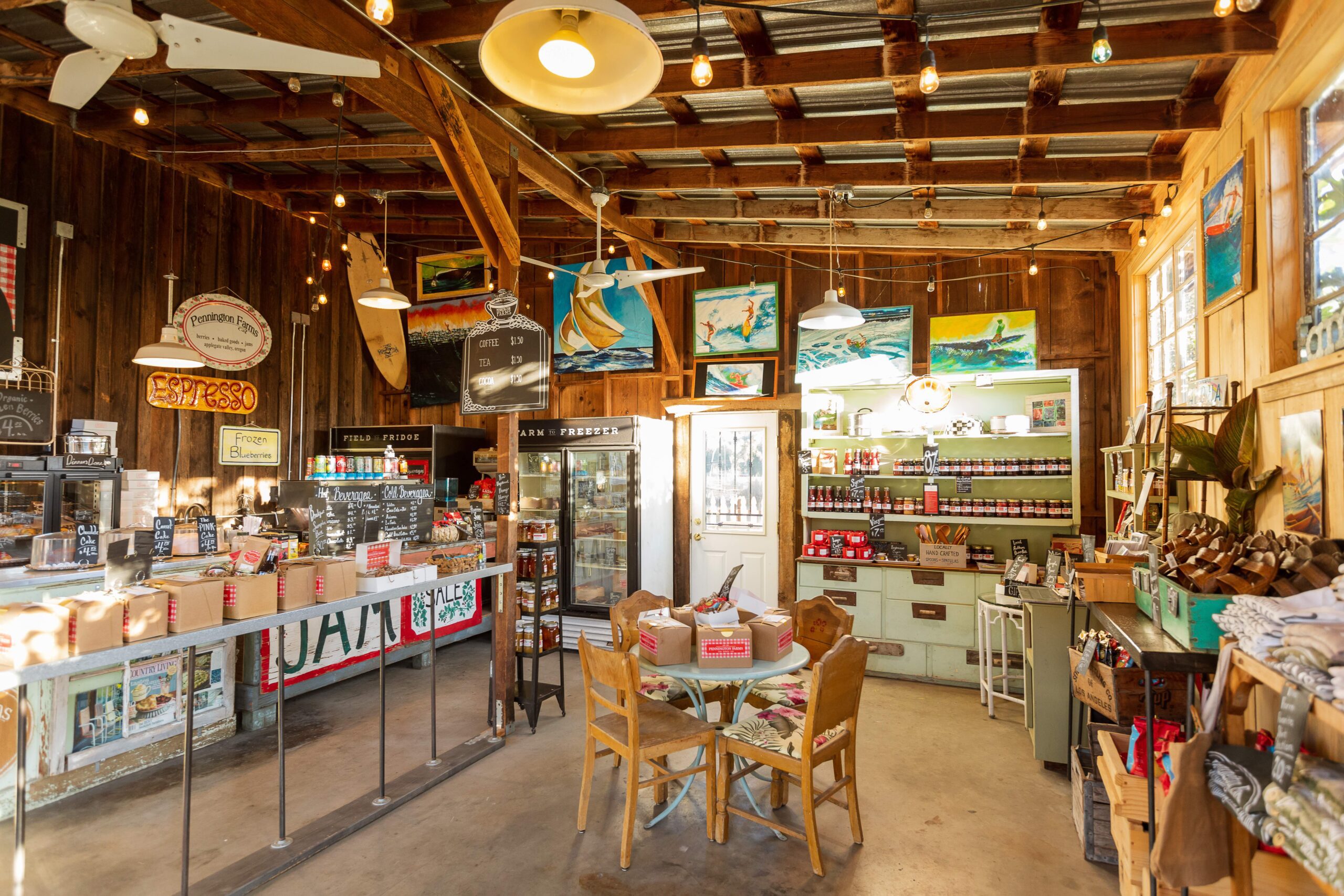 The Pennington Shop has a tall cieling with string lights providing an ambiance over the room. The shop is full of life and locally made products, with an assortment of jams and art on the back wall.