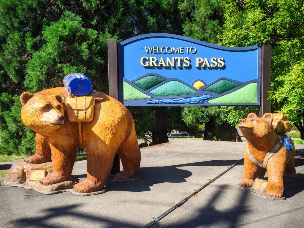 Welcome to Grants Pass sign with two bear statues standing in front