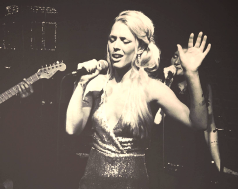 Vintage style photo of Danielle Kelly singing in a glimmering dress.