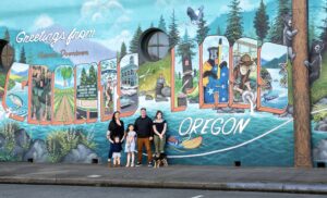 family standing in front of the Welcome to Grants Pass mural