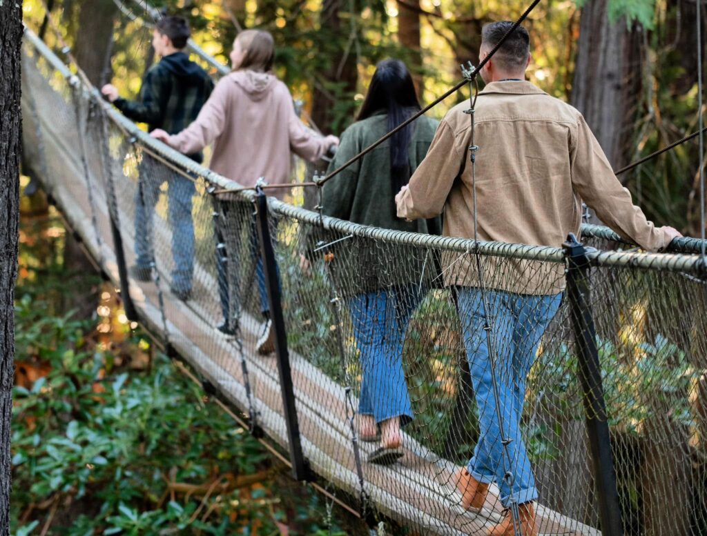 Group walking across rope bridge